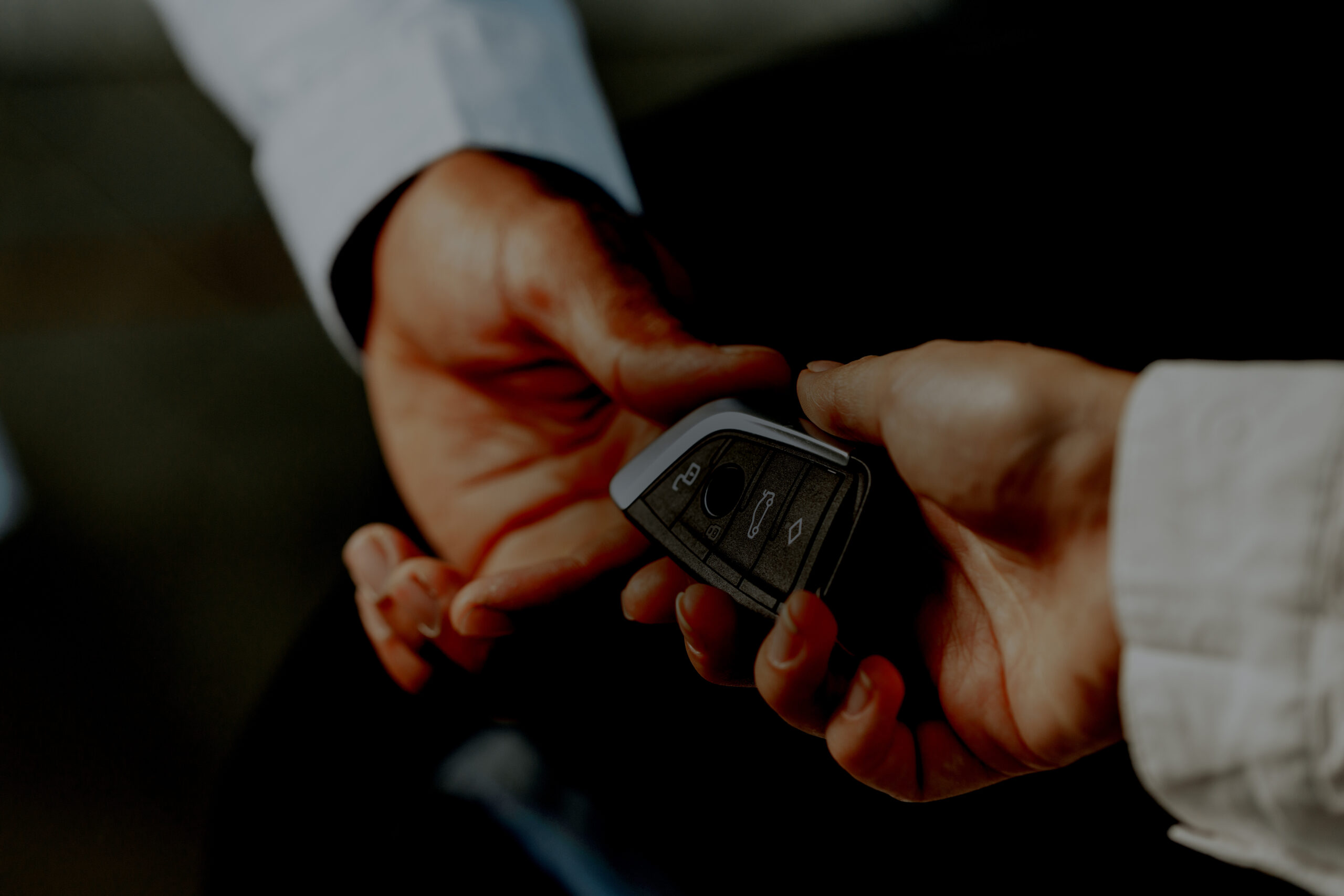 Car salesperson giving keys to a client close up photo